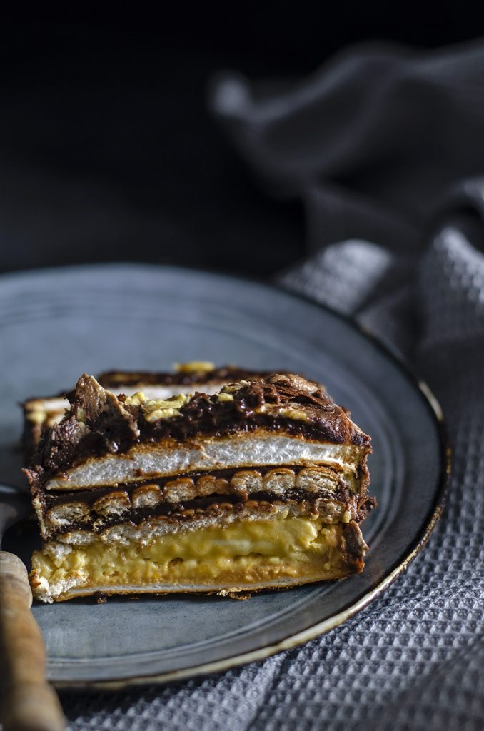 Felie de tort cu blaturi de bezea și biscuiți, cremă de gălbenușuri și ganache