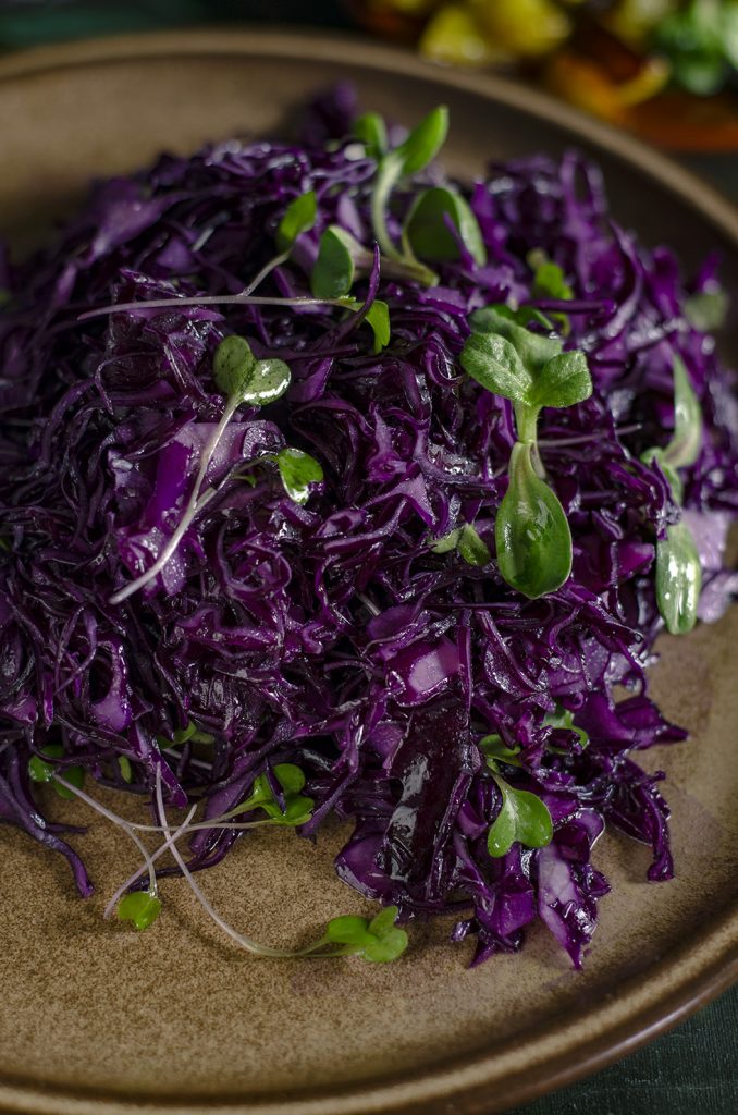 Platou cu salată de varză mov cu vlastari de gulii mov și floarea soarelui